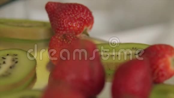 草莓和猕猴桃躺在盘子上在宏观镜头高清上拍摄特写镜头视频的预览图