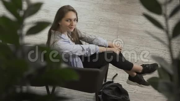 女人坐在椅子上对着镜头微笑视频的预览图