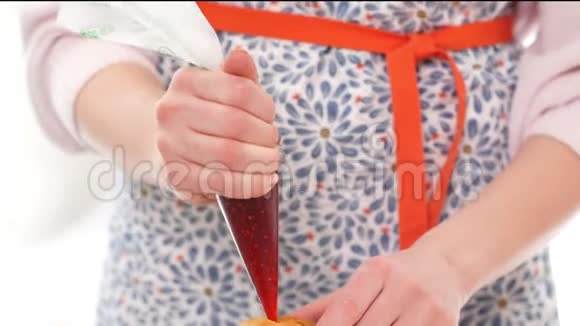 女用手用糕点包用草莓糖浆填充纸杯蛋糕视频的预览图