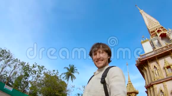 泰国普吉岛上一个男子在瓦查龙寺的佛光中自拍的慢镜头视频的预览图