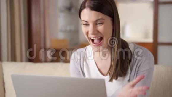 女商人在家里用笔记本电脑女商人听到好消息兴奋开心的微笑视频的预览图
