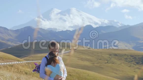 一对年轻夫妇在山上阳光明媚的日子视频的预览图