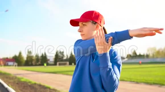 日落时分女人在体育场慢跑前做热身运动视频的预览图