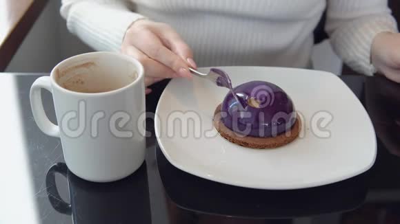 美味的甜点一个女人在咖啡馆里拿着蛋糕喝咖啡视频的预览图