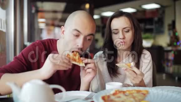 一男一女在披萨店里吃披萨午餐是快餐视频的预览图