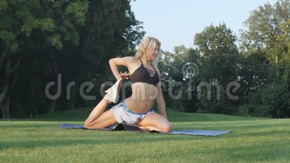 年轻女子在阳光明媚的公园里伸展健身女孩在户外训练自然景观适合女性工作视频的预览图
