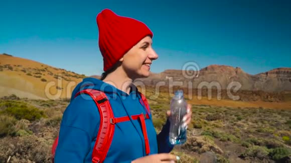 徒步旅行的女人在Tenerife的Tide徒步旅行后喝水加那利群岛特内里费的白人女性游客慢慢视频的预览图