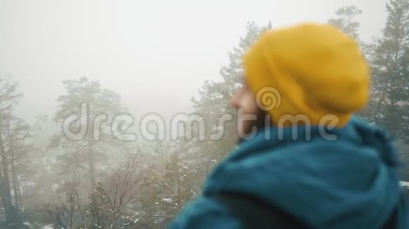 男人环顾四周站在满是雾的山顶上视频的预览图