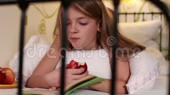 女孩喜欢一本好书和一个多汁的红苹果视频的预览图