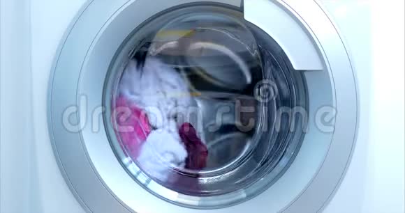 关闭工业洗衣机洗涤彩色服装和白色亚麻白色条纹服装气缸旋转视频的预览图