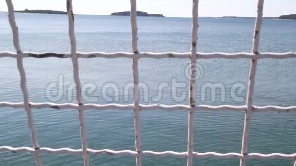 背景中蓝色海铁栅栏的视图安全网俯瞰大海特写视频的预览图