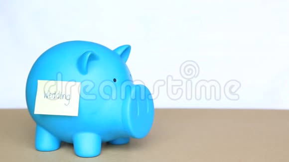 在蓝储存罐里插入硬币上面有粘便条和婚礼词说明为婚礼存钱的概念视频的预览图