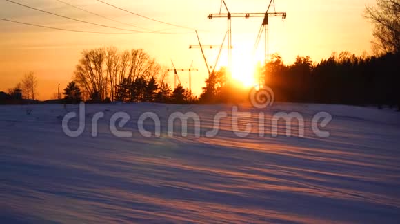 电力塔冬季雪场日落时的电力线能源供应4k视频的预览图