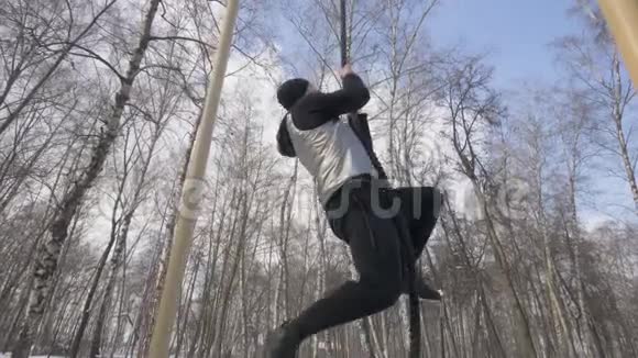 强壮的男子在运动场户外锻炼时攀爬绳索视频的预览图