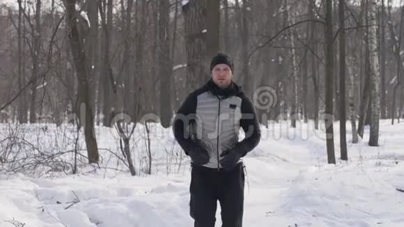 运动男子跑步在冬季城市公园晨跑冬季森林慢跑视频的预览图