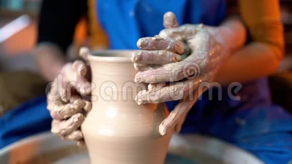 波特和他的女学生的手男人和女人一起工作在陶工轮上制造粘土制品视频的预览图