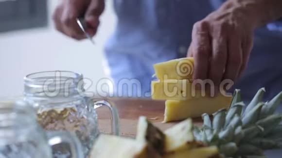 厨师手在木切割板上切菠萝准备水果甜点的男人视频的预览图