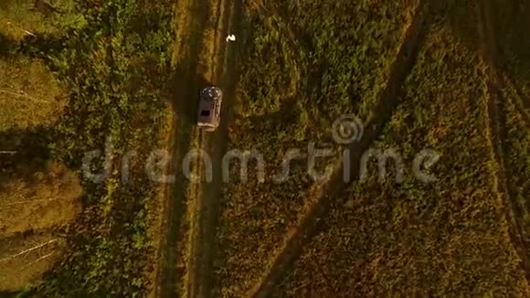 Hitchhiker在农村公路上在田里抓车录像在乡村的搭便车者坐下来欣赏车的美景视频的预览图
