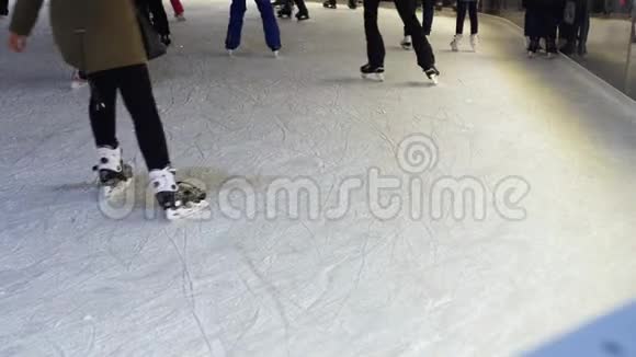 在冬天的晚上溜冰者的脚在冰面上掠过视频的预览图