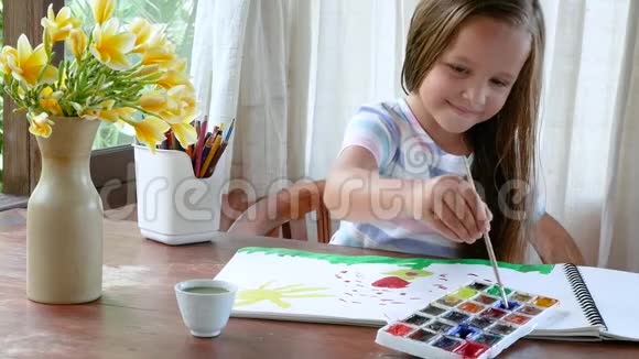 儿童浸泡画笔上色并在窗户附近画画视频的预览图