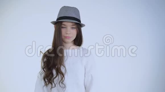 戴着帽子的漂亮年轻活泼的女孩在镜头前摆姿势视频的预览图