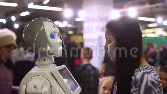 一个女孩和一个女机器人交流并微笑现代机器人技术人工智能控制论视频的预览图