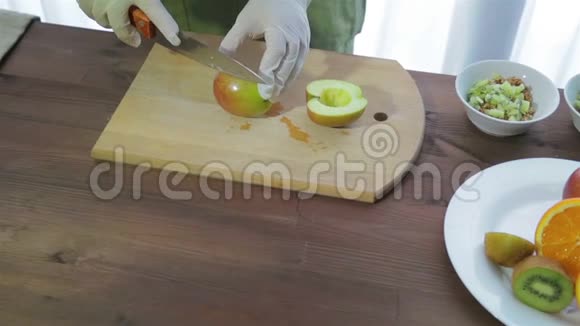 一个女人正在用刀子在木板上切苹果摄像机从左向右移动视频的预览图