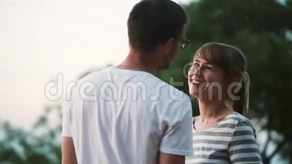 年轻的幸福夫妇在大自然上度过美好的时光美丽的男人和女人拥抱微笑亲吻视频的预览图