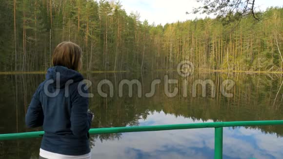 女孩在森林里用电话拍照视频的预览图