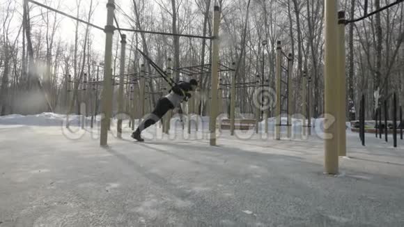 健身男子在冬季运动场上用运动带锻炼体育生活视频的预览图
