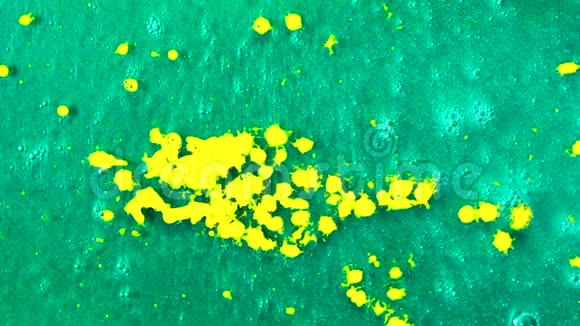 俯视黄色颜料滴落到美丽的绿松石表面艺术理念液体黄色墨水滴下来视频的预览图