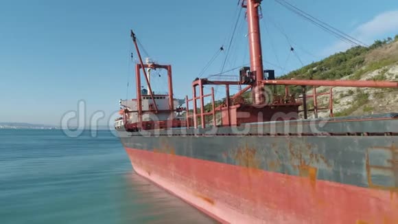 靠近海岸的码头上大型红色货船的特写镜头射击海上运输视频的预览图