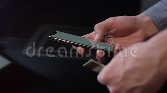男子手持信用卡使用智能手机在线支付视频的预览图