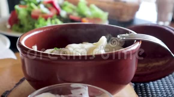 泥锅里的饺子带蒸汽的热食视频的预览图
