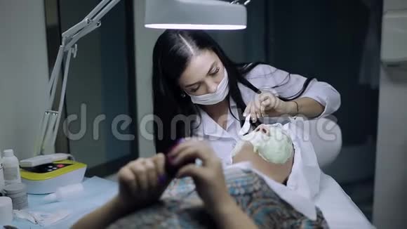 美容师给一个皮肤有问题的年轻女孩戴上面具视频的预览图
