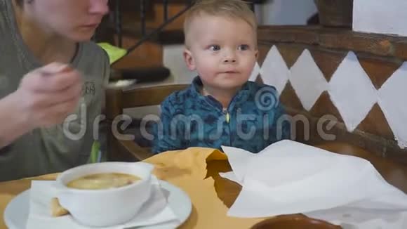 妈妈在咖啡馆里给婴儿喂漂亮的汤美味可口视频的预览图