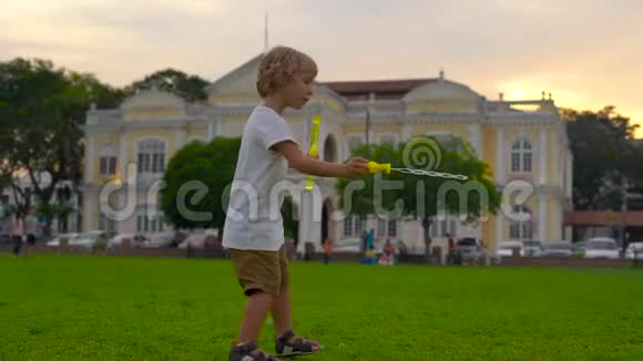 一个小男孩在乔治敦市政厅前的广场上玩泡泡鼓风机的慢镜头视频的预览图