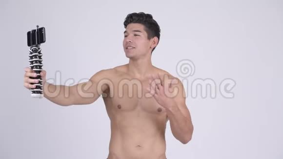 年轻的无衫肌肉男用电话视频的预览图