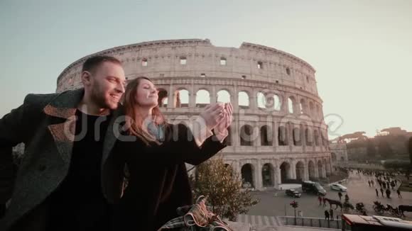 快乐的年轻夫妇在意大利罗马斗兽场附近自拍旅行的男人和女人在镜头里微笑视频的预览图