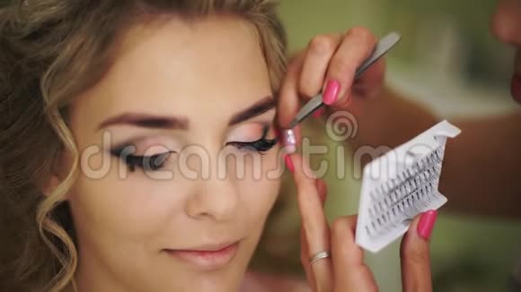 新娘用假睫毛粘合专业化妆为女性健康年轻的面部皮肤视频的预览图