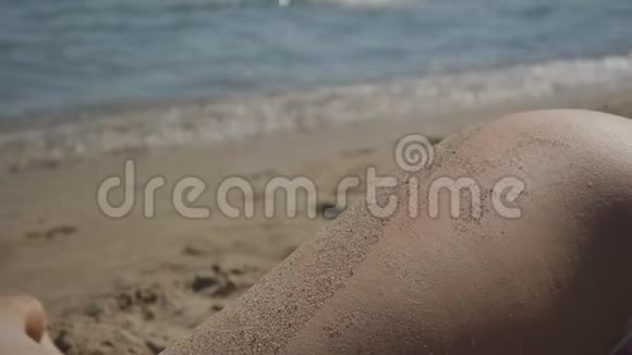 白种人妇女臀部的特写躺在海边的沙滩上视频的预览图