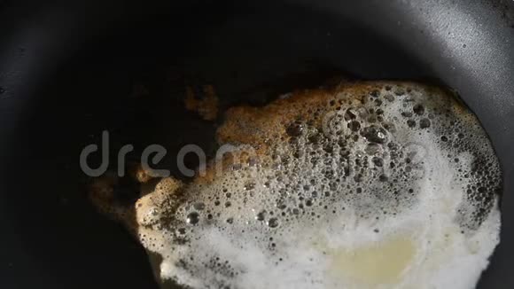 在不粘平底锅中缓慢移动的黄油熔化滚烫的褐变立方体视频的预览图