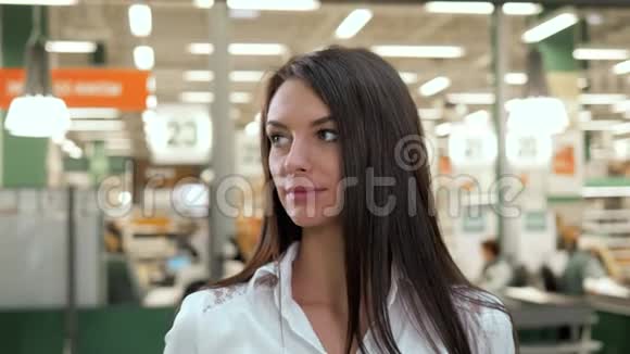 在购物中心拿着数码平板电脑的女人看着相机和微笑的杂货店视频的预览图