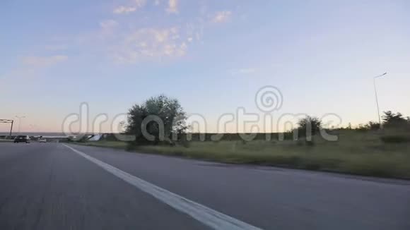 从田野上的一辆移动的汽车和五彩缤纷的日落中观看大自然有一扇车窗视频的预览图