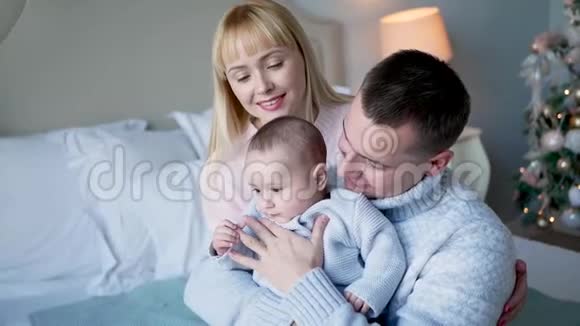 父母都和一个小儿子坐在床上视频的预览图