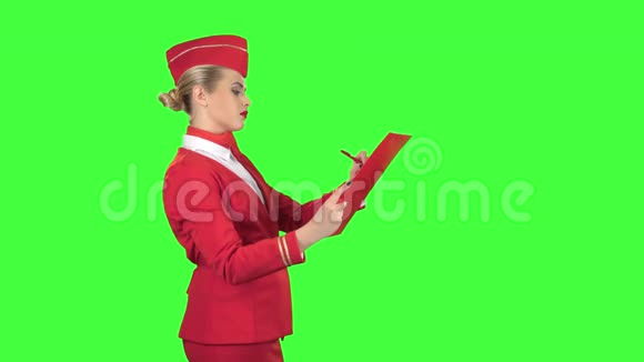 女孩在一个特殊的文件夹里写一支钢笔她是一名空姐绿色屏幕侧视图视频的预览图