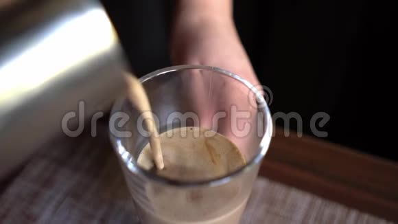 把咖啡师把可可从银罐里倒入玻璃杯里视频的预览图