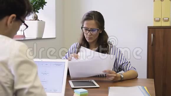 年轻员工讨论坐在公司的工作文件视频的预览图