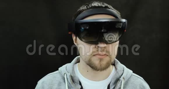 增强现实眼镜年轻的白种人使用全息增强现实眼镜游戏开发视频的预览图