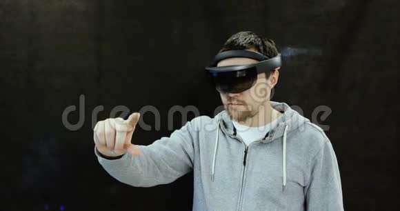增强现实眼镜年轻的白种人使用全息增强现实眼镜游戏开发视频的预览图